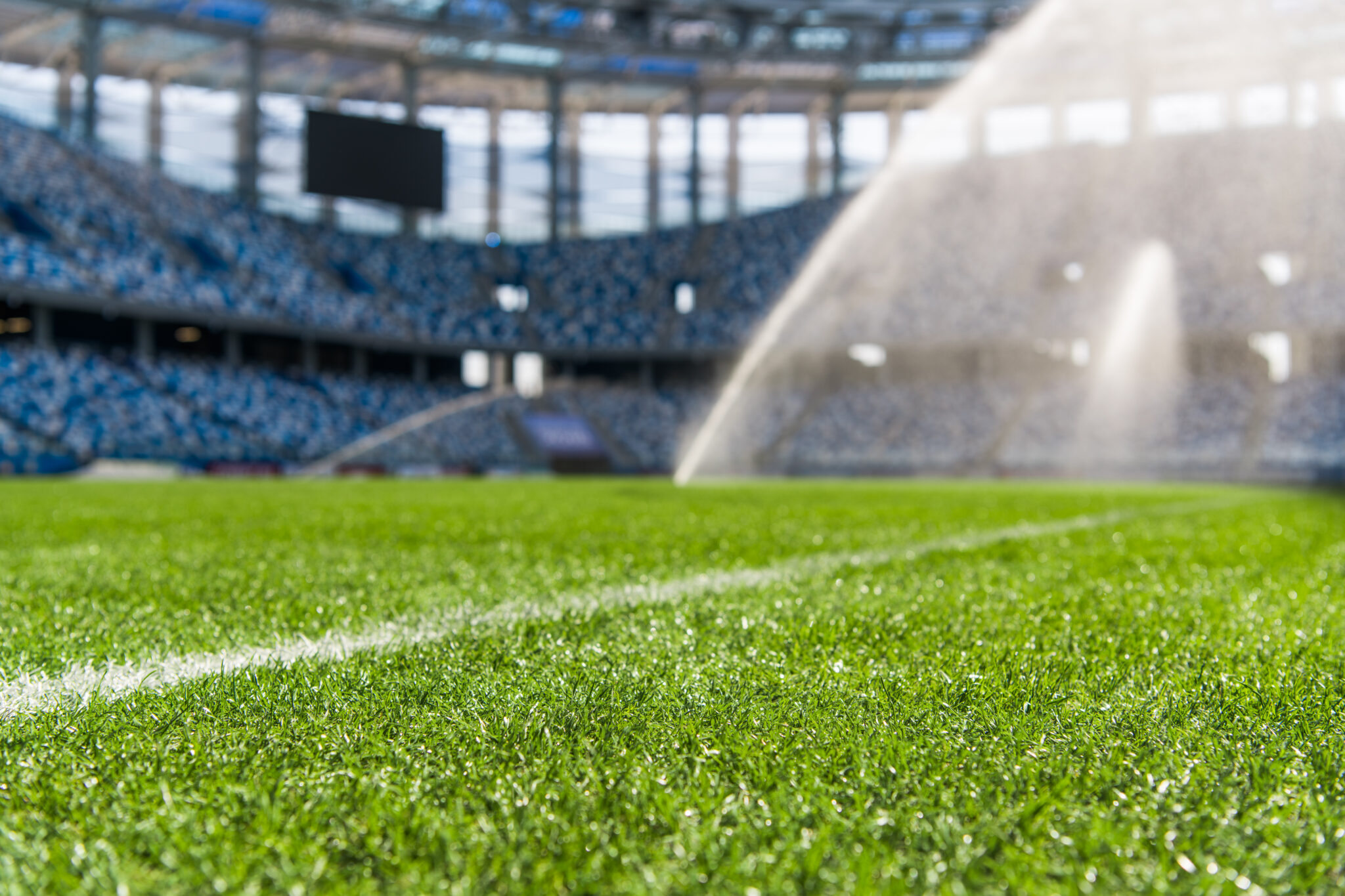 Beregening boven een sportveld in een leeg stadion